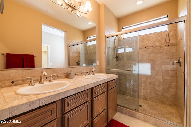 full bath with tile patterned flooring, double vanity, a stall shower, and a sink