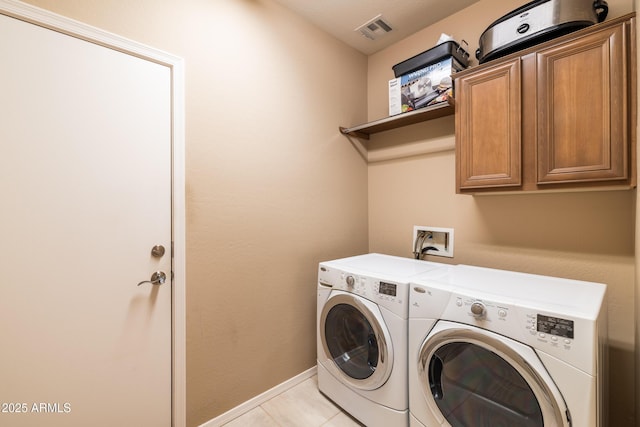 washroom featuring baseboards, cabinet space, visible vents, and washer and clothes dryer