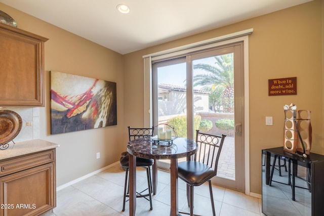 dining area featuring light tile patterned flooring and baseboards