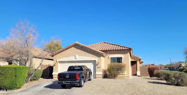 mediterranean / spanish-style home featuring fence, a tile roof, stucco siding, a garage, and driveway