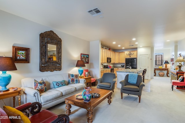 living area with recessed lighting, visible vents, and light colored carpet