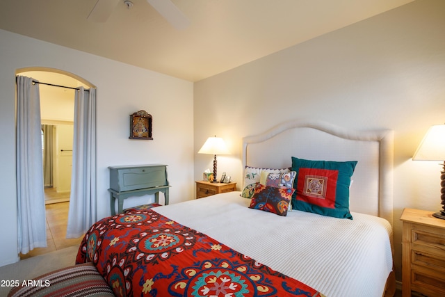 bedroom with arched walkways and ceiling fan