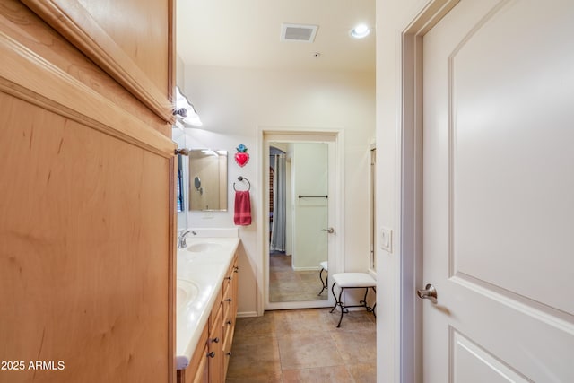 bathroom featuring double vanity, visible vents, and a sink