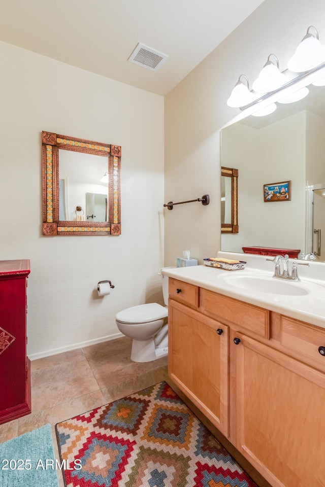 bathroom featuring vanity, baseboards, visible vents, tile patterned floors, and toilet