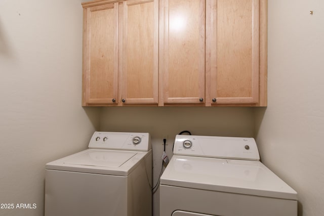 clothes washing area with washer and clothes dryer and cabinet space