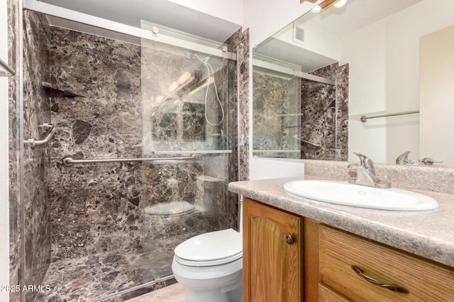 bathroom featuring visible vents, vanity, toilet, and a shower stall