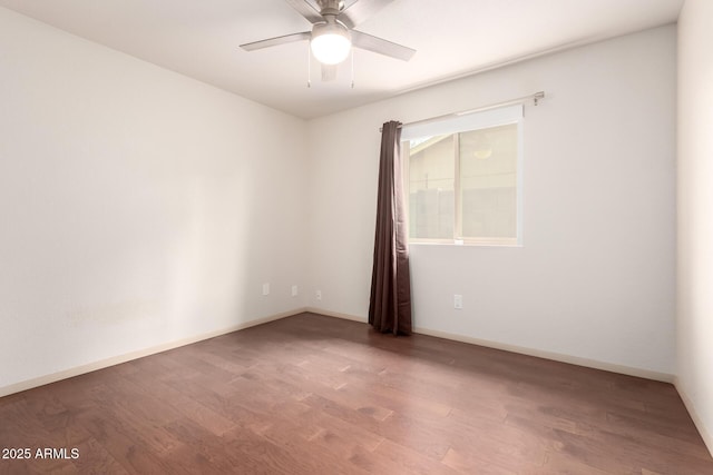 unfurnished room with a ceiling fan, baseboards, and wood finished floors