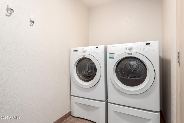 laundry room featuring laundry area, baseboards, and washing machine and clothes dryer