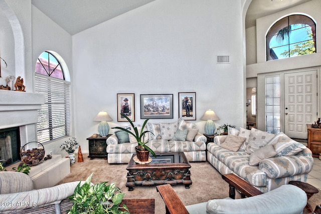 8120 E Cortez Dr, Scottsdale, AZ 85260 - living room featuring high vaulted ceiling, healthy amount of natural light, a fireplace with raised hearth, and arched walkways