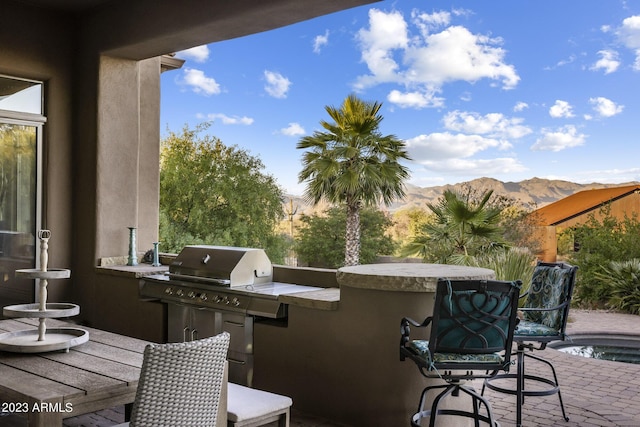 view of patio / terrace with a mountain view, area for grilling, and a swimming pool