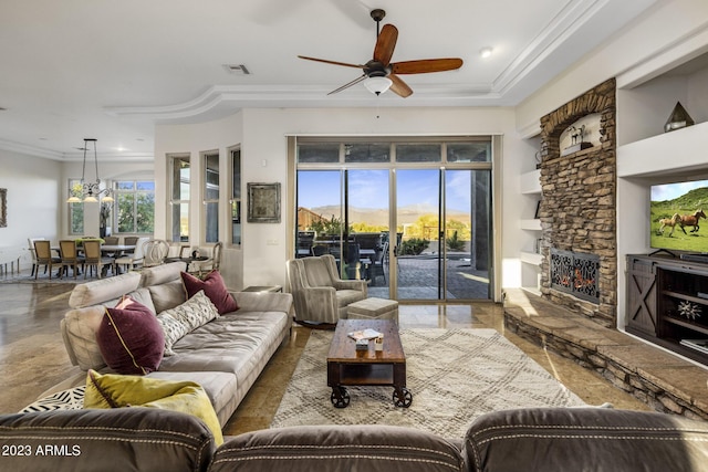 living room featuring ceiling fan, crown molding, a fireplace, and built in shelves