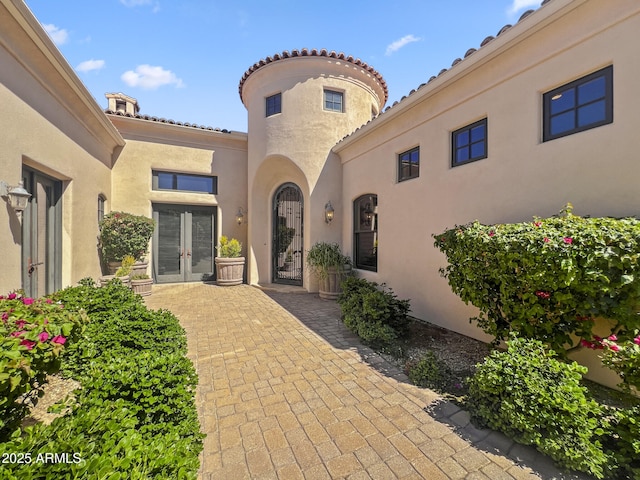 view of exterior entry with stucco siding and french doors