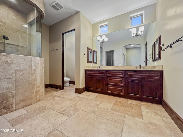 full bathroom featuring a sink, baseboards, a walk in shower, and stone tile floors
