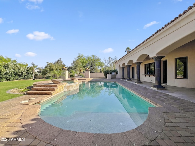 view of pool featuring a pool with connected hot tub, a patio area, and area for grilling
