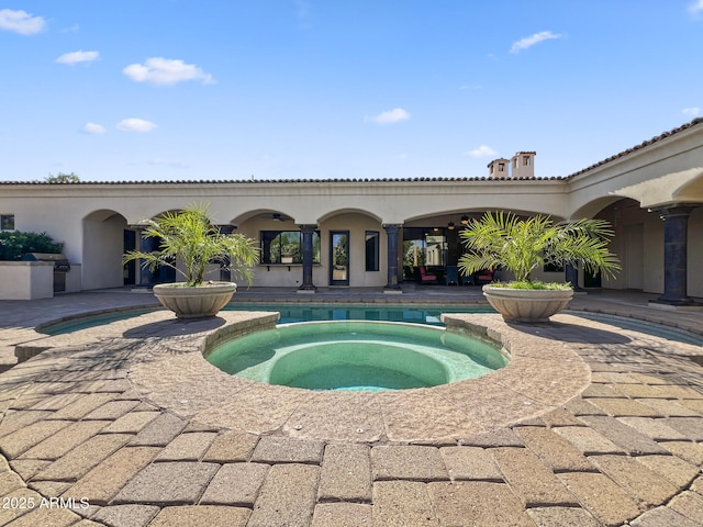 view of pool with a patio, an in ground hot tub, and grilling area