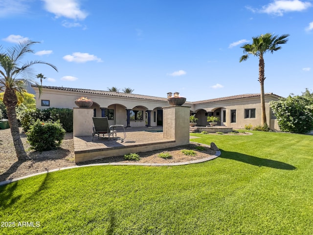 back of house with a lawn and stucco siding