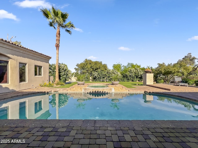 pool featuring a patio and an in ground hot tub