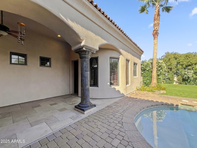 view of patio / terrace with a ceiling fan and an outdoor pool