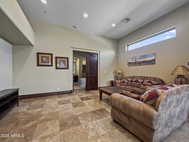 living room with baseboards, stone finish flooring, recessed lighting, and visible vents