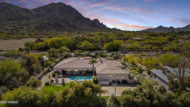 aerial view at dusk featuring a mountain view