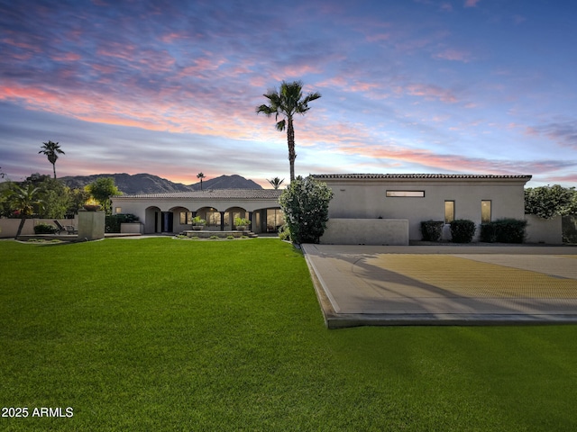 view of front facade with a lawn and stucco siding