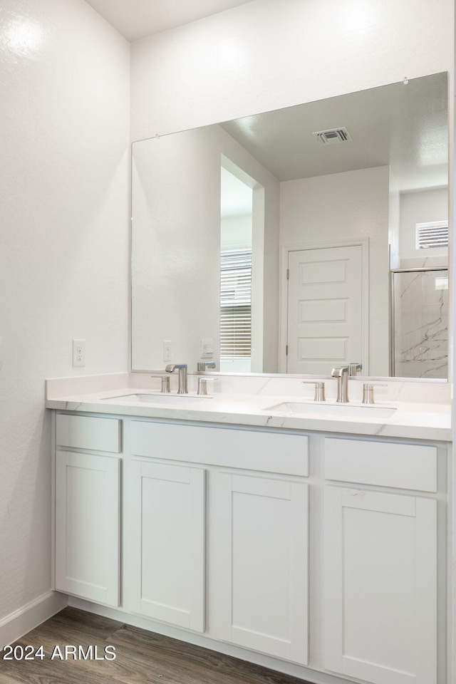 bathroom featuring hardwood / wood-style floors, vanity, and walk in shower