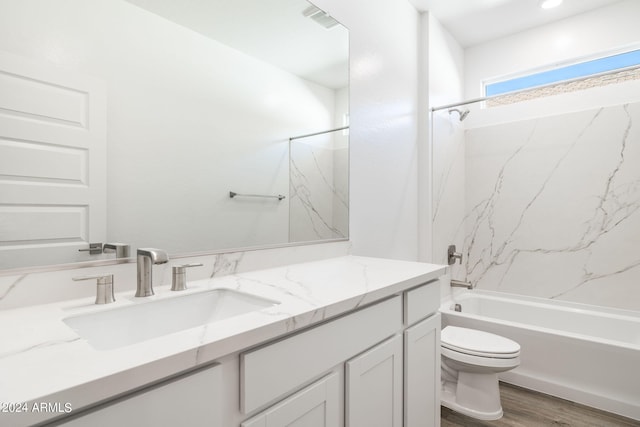 full bathroom with hardwood / wood-style floors, vanity, shower / bath combination, and toilet