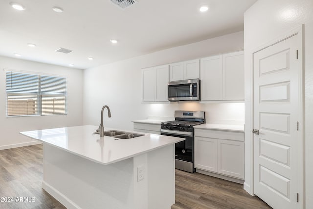 kitchen featuring a kitchen island with sink, sink, white cabinets, and stainless steel appliances