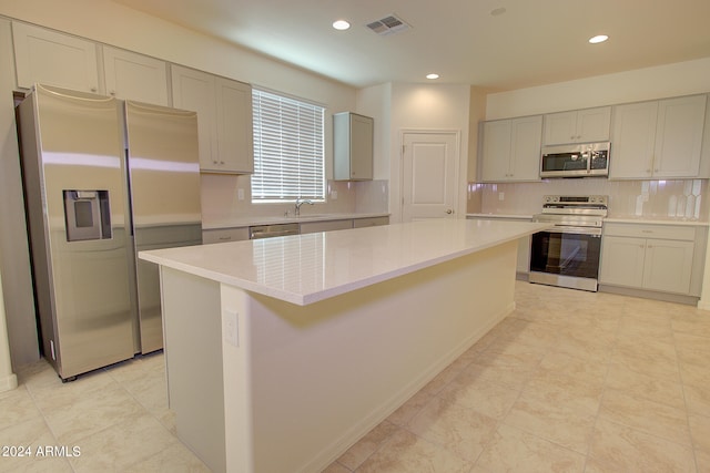 kitchen featuring sink, a kitchen island, appliances with stainless steel finishes, and backsplash