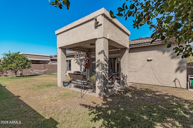 back of house featuring a lawn and a patio area