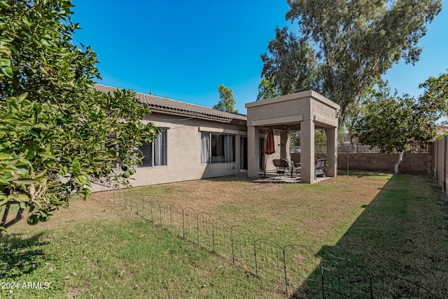 back of house with a yard and a patio area