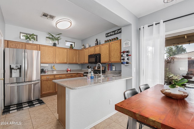 kitchen featuring sink, kitchen peninsula, appliances with stainless steel finishes, a kitchen bar, and light tile patterned floors