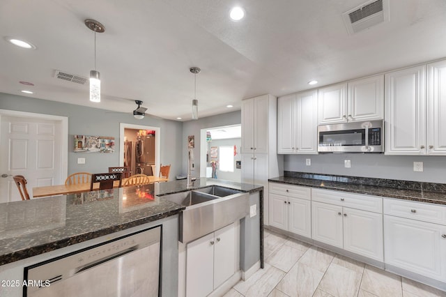 kitchen with white cabinetry, appliances with stainless steel finishes, and pendant lighting