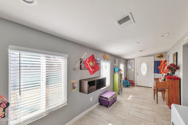 entryway with a healthy amount of sunlight and vaulted ceiling