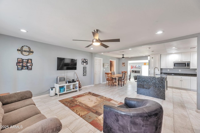 living room featuring sink and ceiling fan