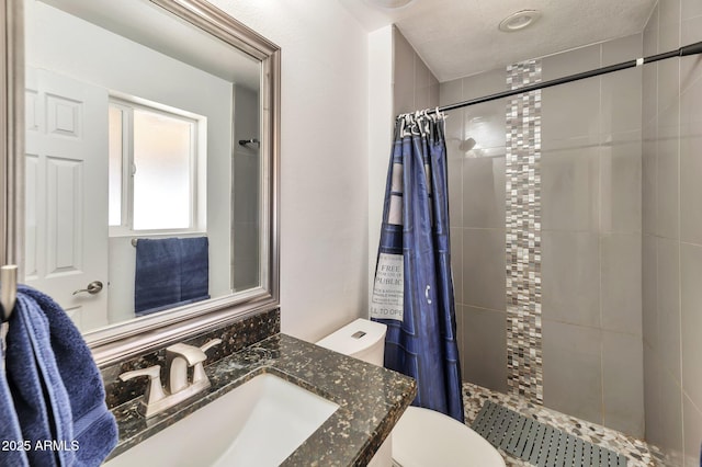 bathroom featuring vanity, toilet, curtained shower, and a textured ceiling