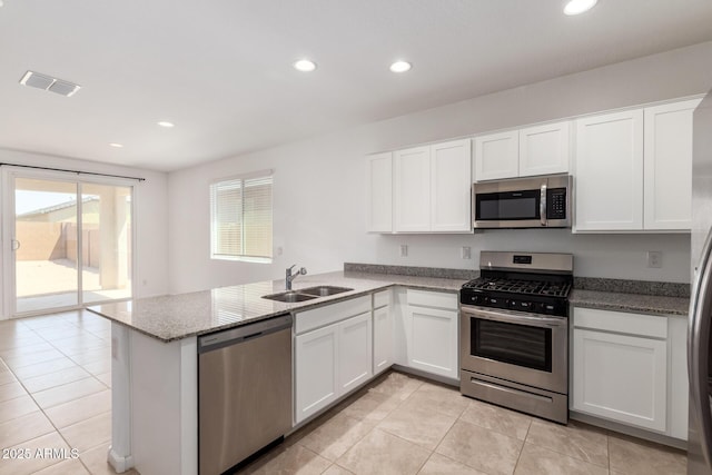 3036 E Riding Boot Way, San Tan Valley, AZ 85140 - kitchen featuring appliances with stainless steel finishes, a sink, a peninsula, light tile patterned floors, and white cabinetry