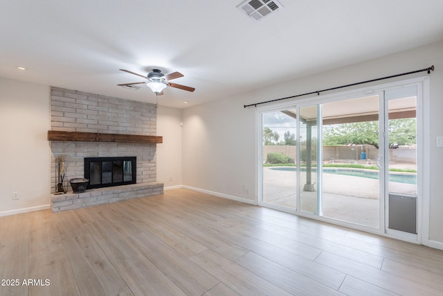 unfurnished living room featuring ceiling fan, wood finished floors, baseboards, and healthy amount of natural light