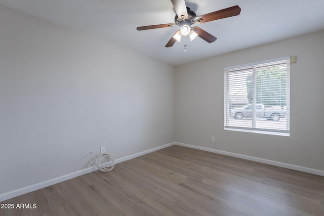 empty room featuring wood finished floors, ceiling fan, and baseboards