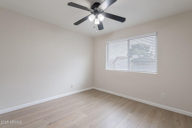 empty room featuring baseboards, light wood-type flooring, and ceiling fan