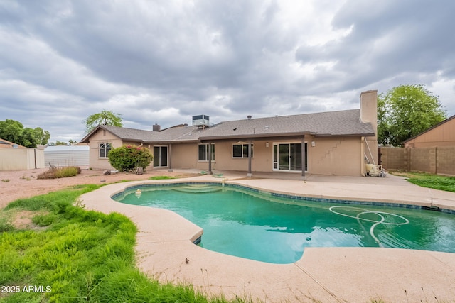 view of swimming pool featuring a patio and fence