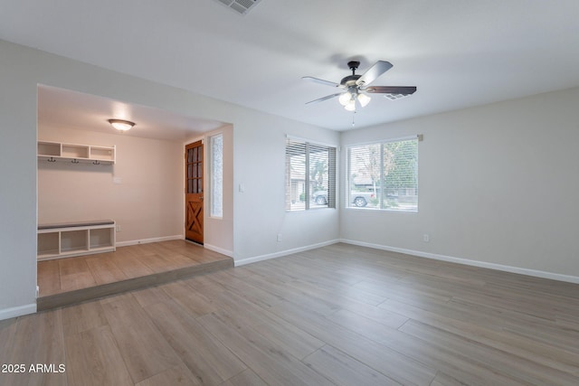 empty room with a ceiling fan, wood finished floors, and baseboards
