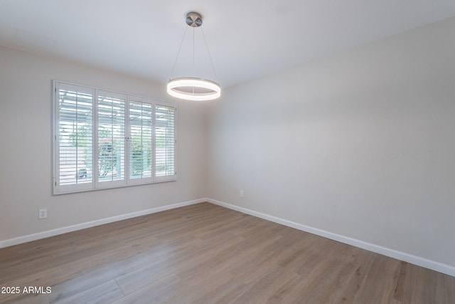 unfurnished room with light wood finished floors and baseboards