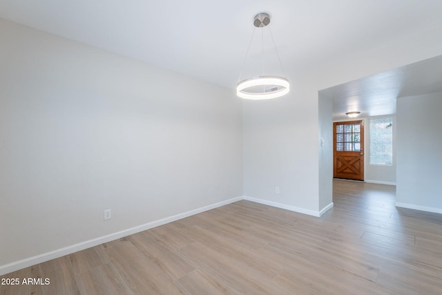 empty room with light wood finished floors and baseboards