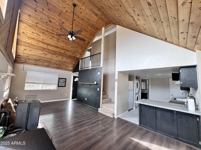 kitchen with freestanding refrigerator, wooden ceiling, dark cabinetry, and a sink