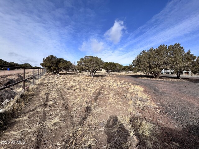 view of yard featuring a rural view and fence