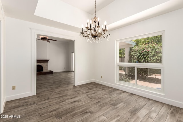 38 E Calavar Rd, Phoenix, AZ 85022 - unfurnished dining area featuring wood finished floors, a chandelier, a ceiling fan, and a fireplace with raised hearth