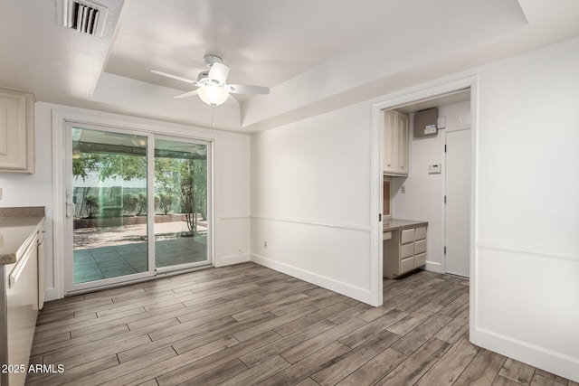 38 E Calavar Rd, Phoenix, AZ 85022 - unfurnished dining area featuring a raised ceiling, ceiling fan, and light wood-type flooring