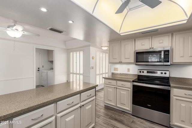 38 E Calavar Rd, Phoenix, AZ 85022 - kitchen featuring appliances with stainless steel finishes, a ceiling fan, washing machine and dryer, wood finished floors, and recessed lighting