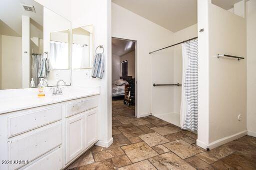 bathroom featuring vanity, a shower with shower curtain, and lofted ceiling